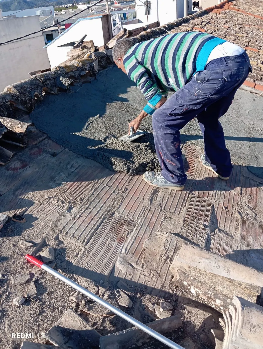 Trabajador aplicando mortero en cubierta antes de impermeabilizar